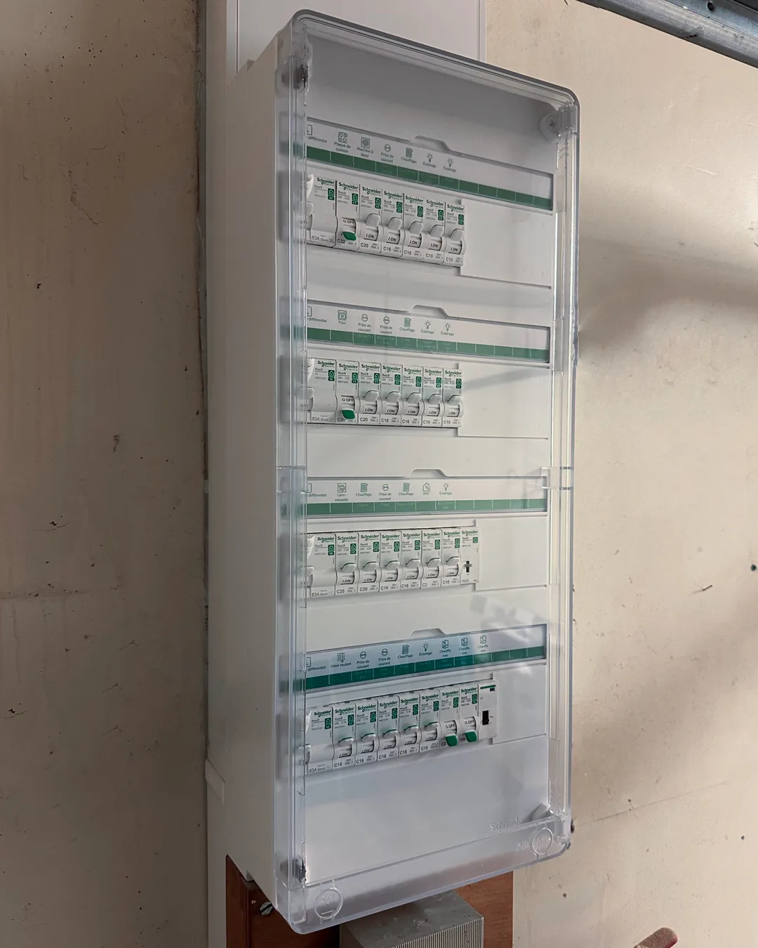 Tableau électrique neuf après rénovation, disjoncteurs alignés et repérés sous capot fermé.